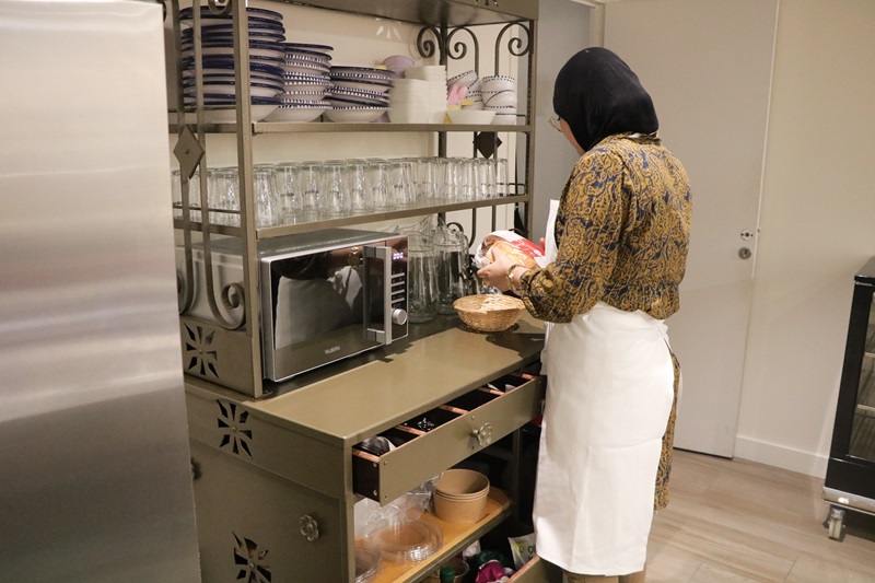 Jeune femme en cuisine au restaurant "Comme à la maison"